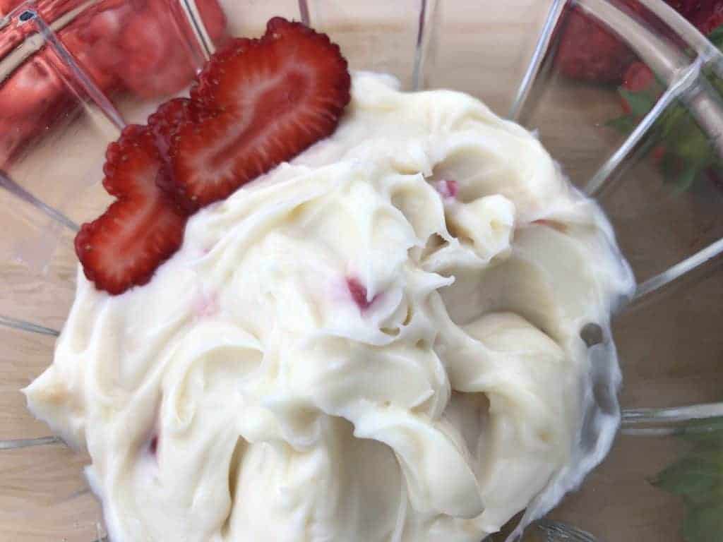 Light and Creamy Berry Infused Dip in a glass bowl with sliced strawberries
