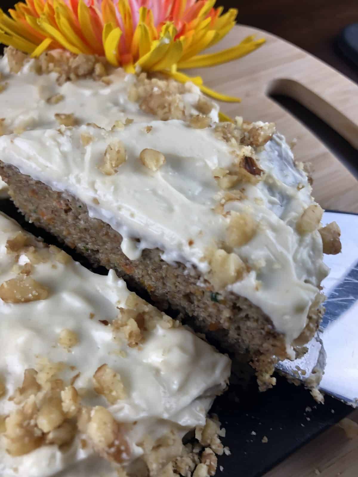 Lifting a slice of keto carrot cake with a spatula