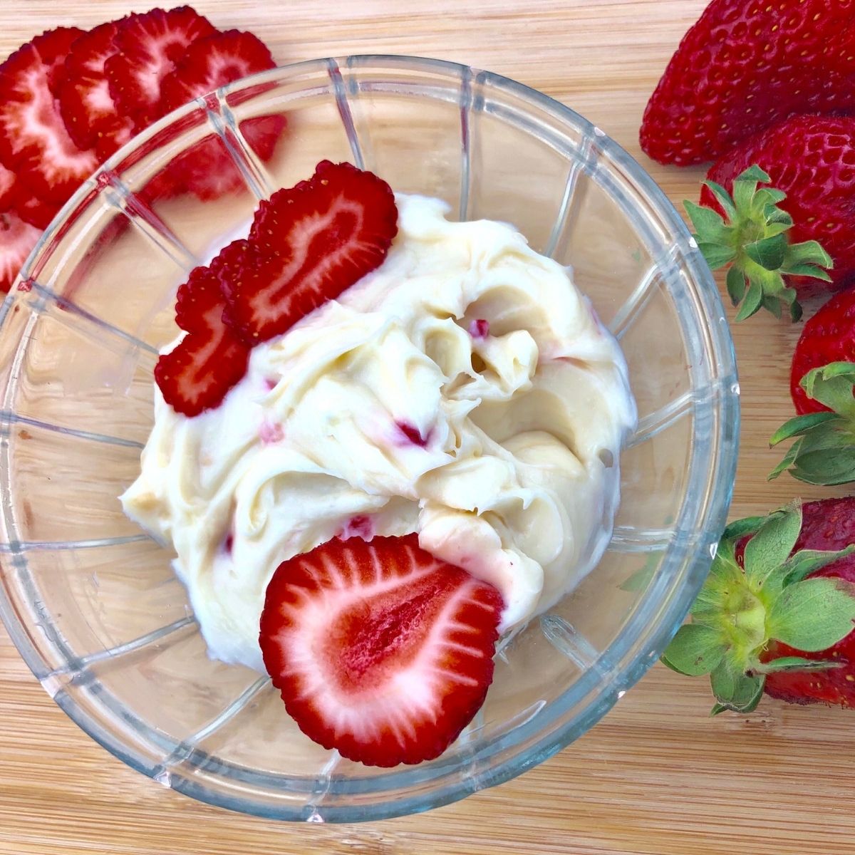 Strawberry Keto Cream Cheese Dip in a round glass bowl with slices strawberries on top