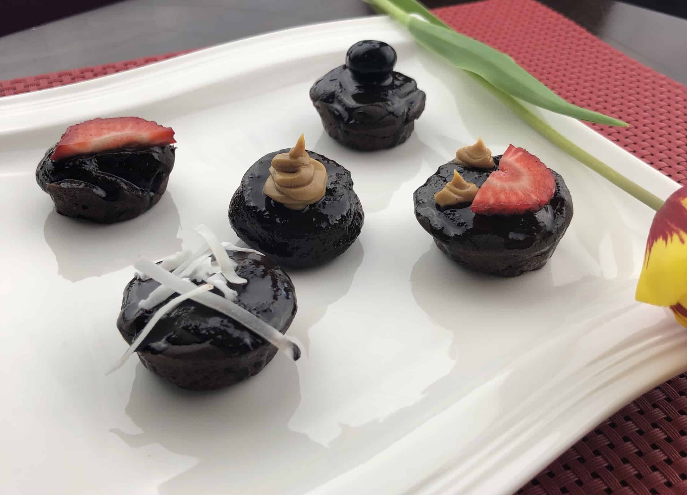 Five mini chocolate cakes on a white plate