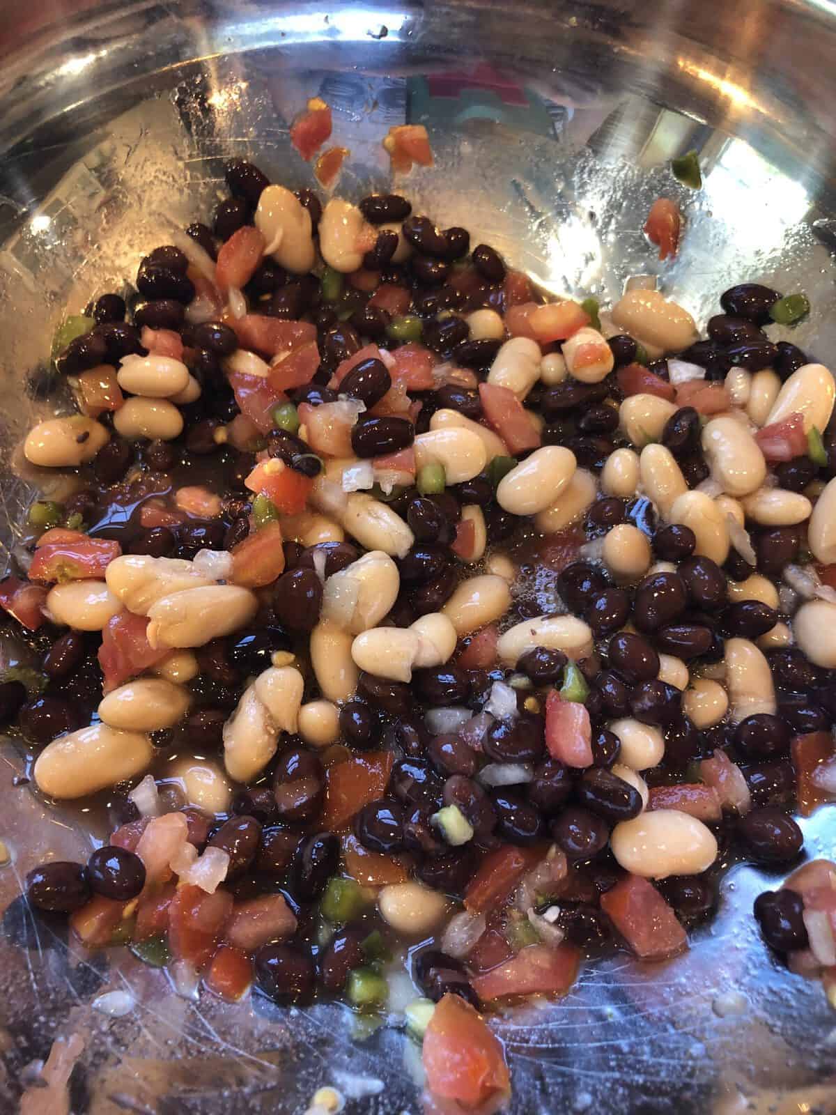 Beans with diced onion in a stainless steel bowl