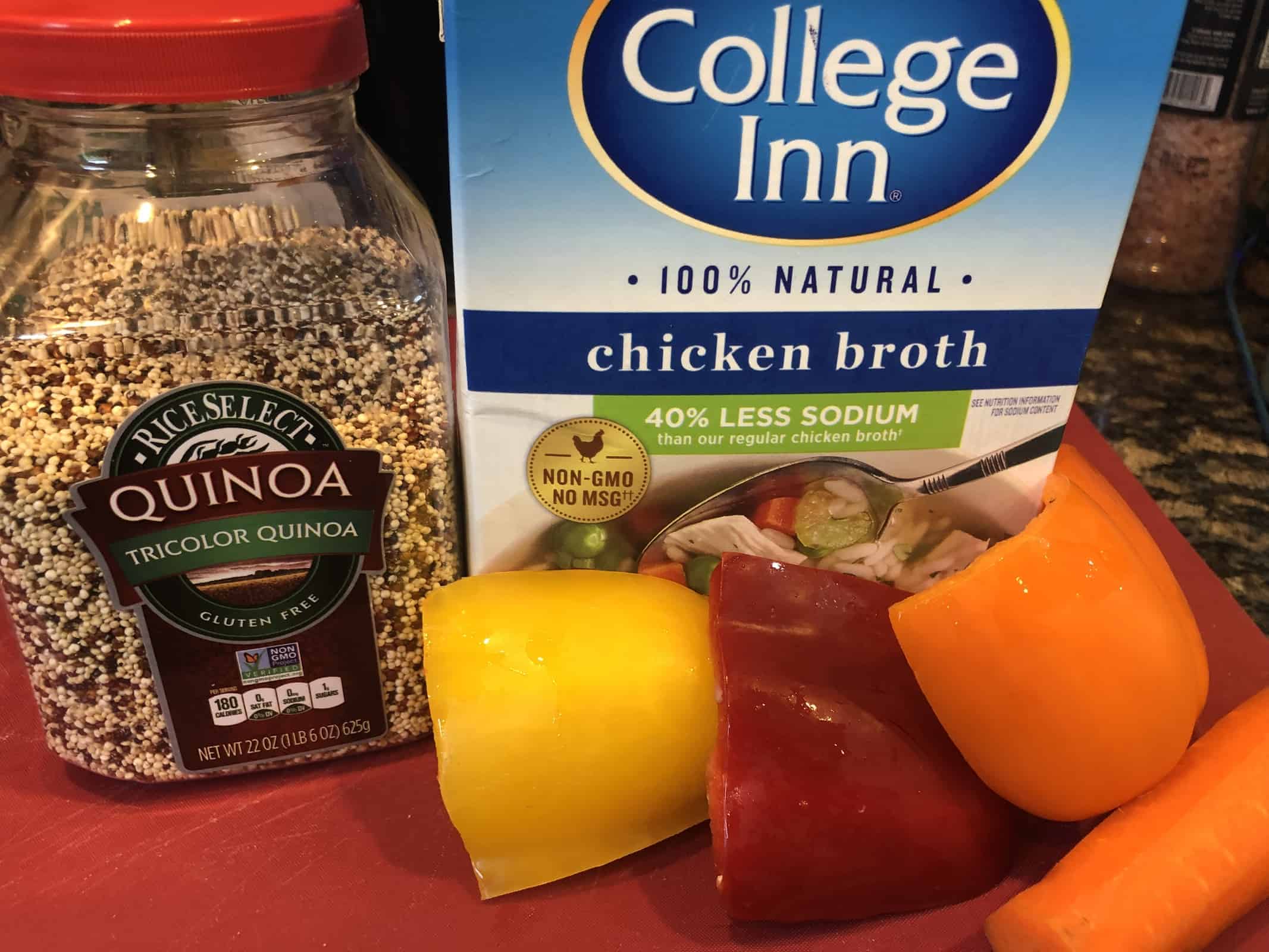 Ingredient display - a container of quinoa, College Inn chicken broth and yellow, red and orange peppers