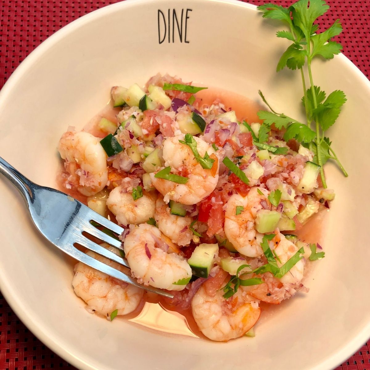 Weight Watchers Zero Point Shrimp Ceviche in a White bowl with the words DINE imprinted on the bowl with a stainless steel fork in the bowl and a sprig of parsley