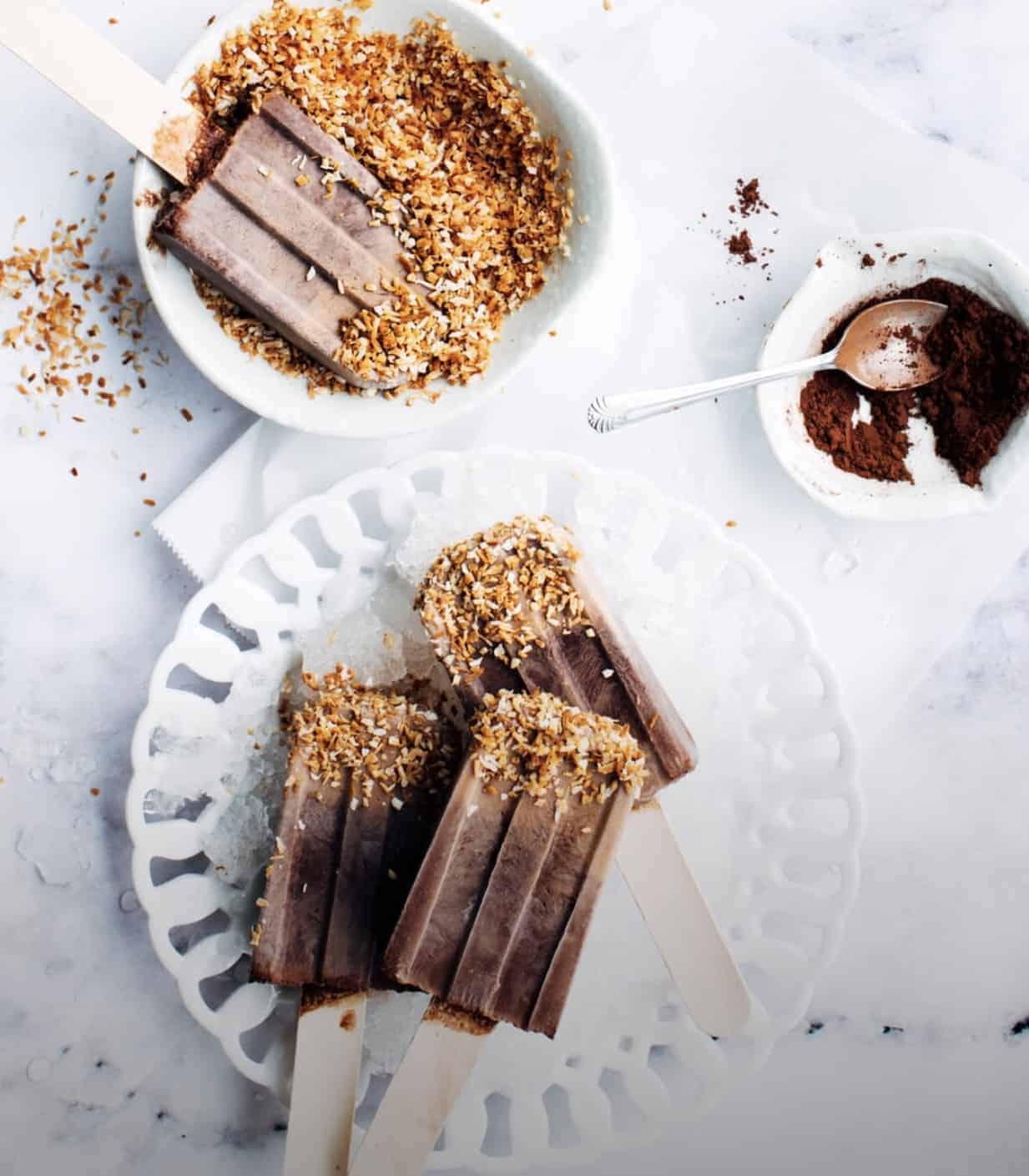  fudge pops on dipped with crushed nuts a white plate