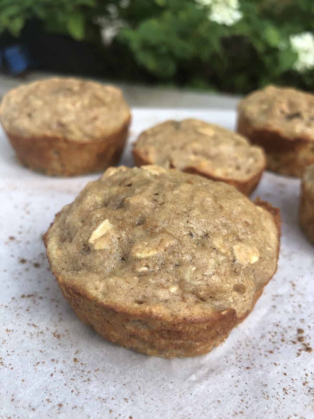  4 cinnamon oat muffins on white parchment paper