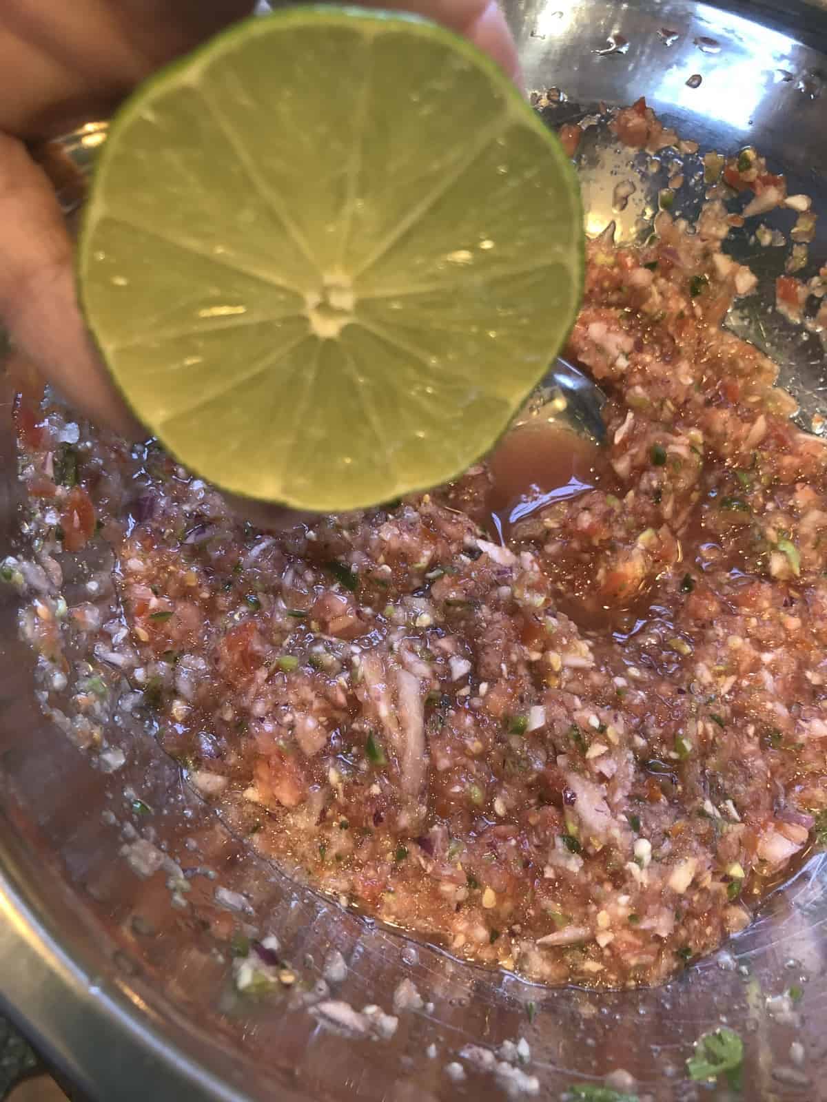 Squeezing a lime  for juice into salsa