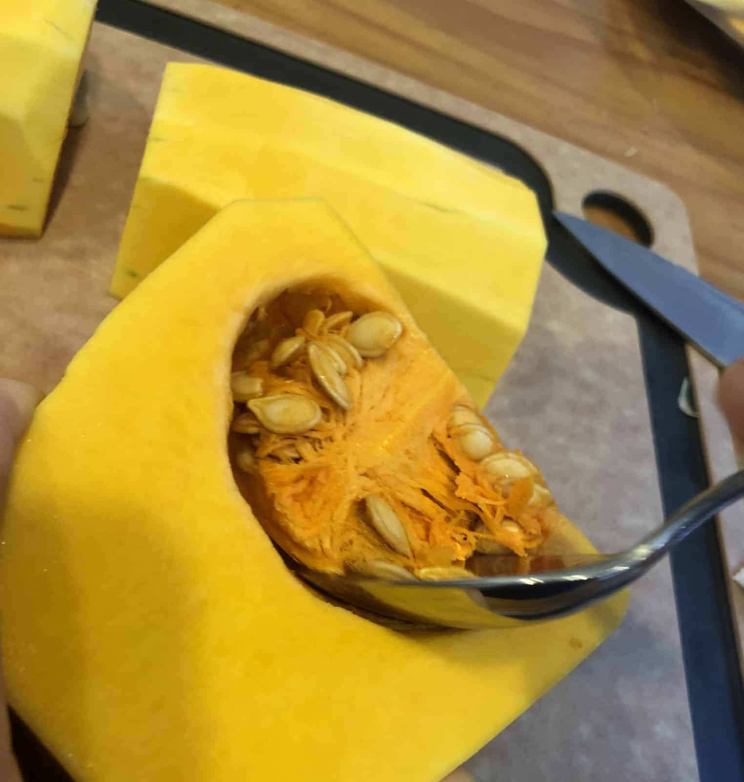 removing seeds from butternut squash with a spoon