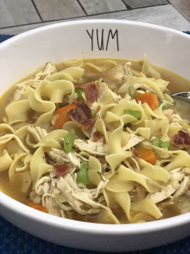 A bowl of Bacon Topped Homestyle Chicken noodle soup