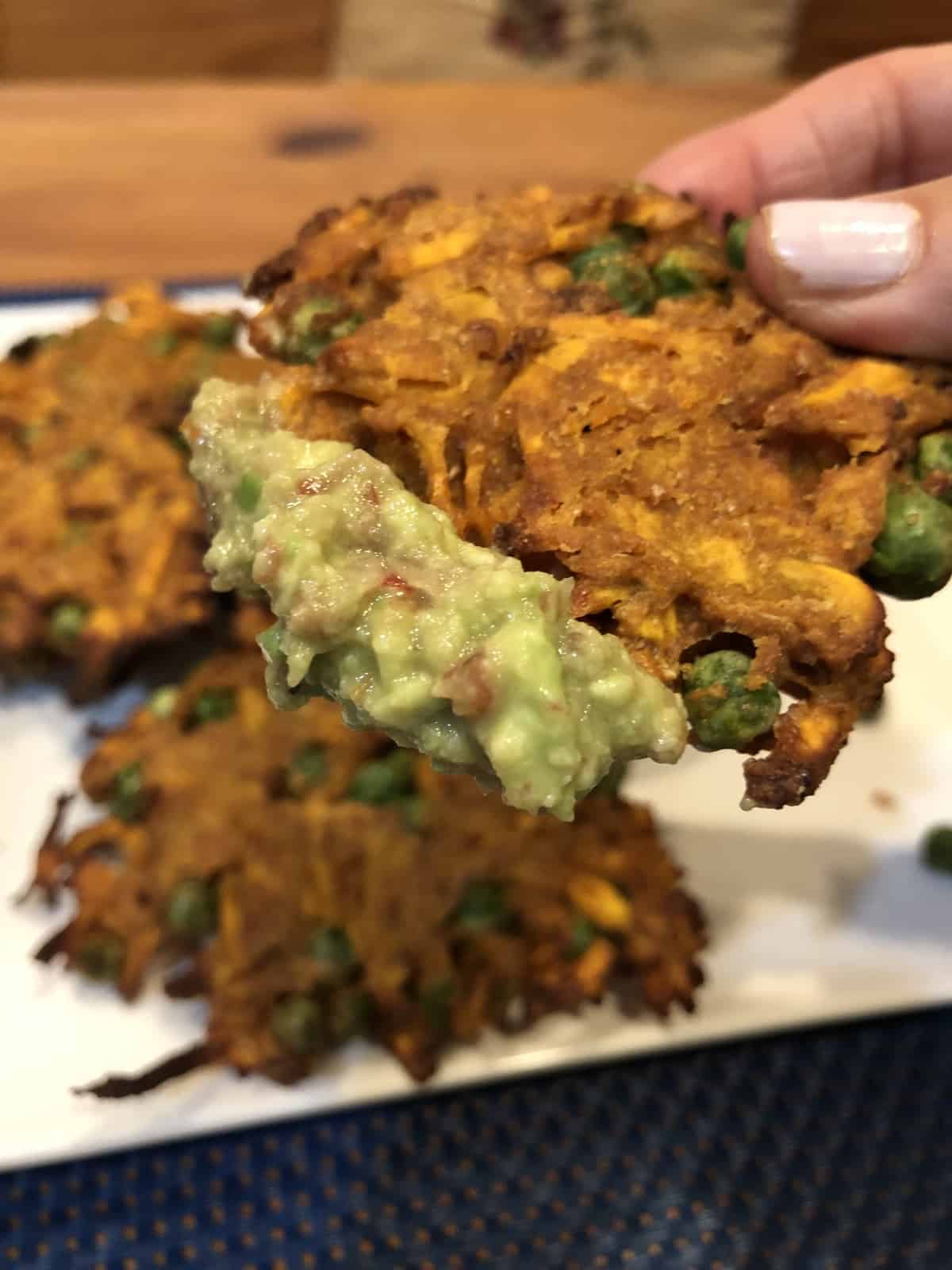 Dipping the Curried Sweet Potato Fritters in guacamole