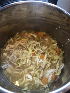 Adding the shredded chicken into the homemade instant pot soup