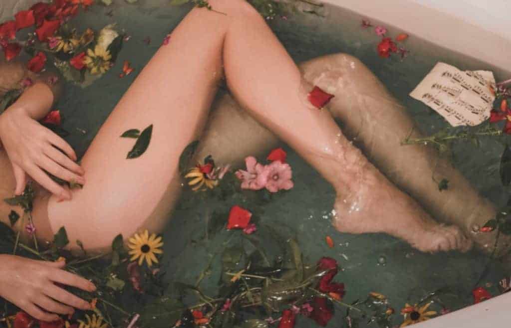 female in bathtub with flowers
