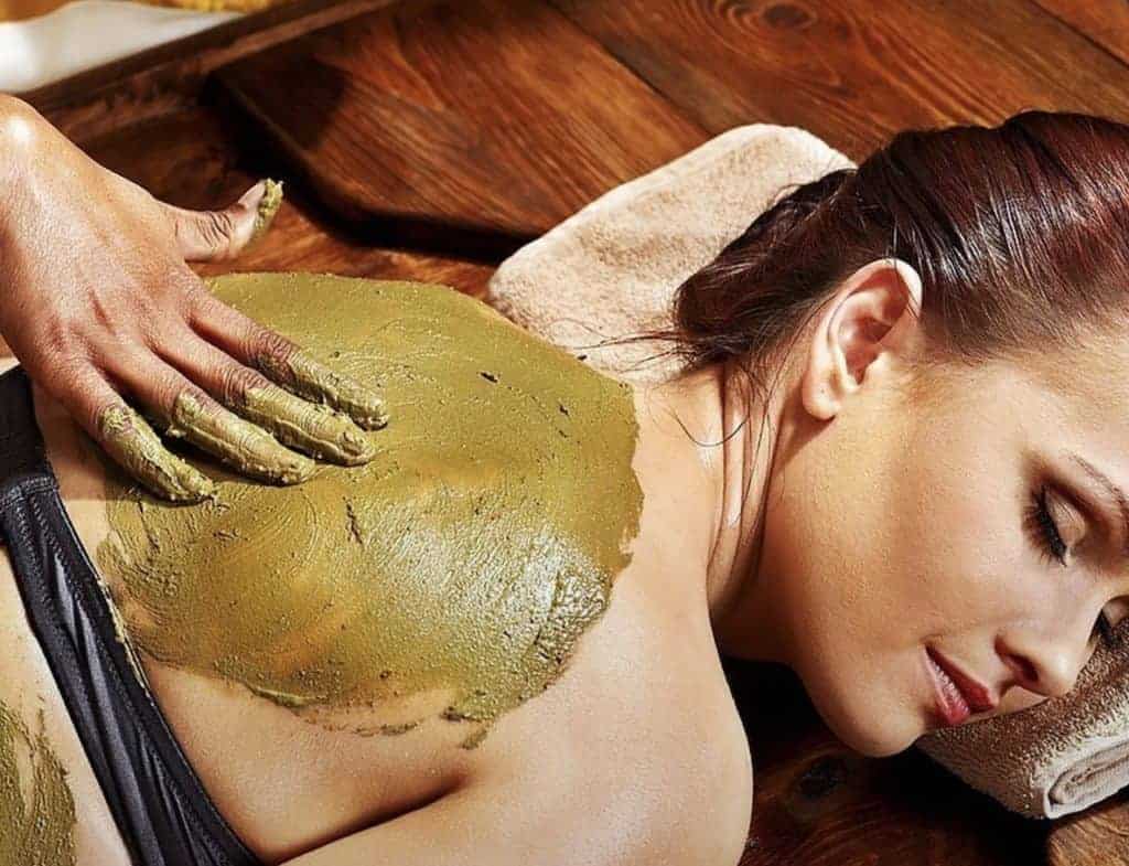 female getting body mask applied on back