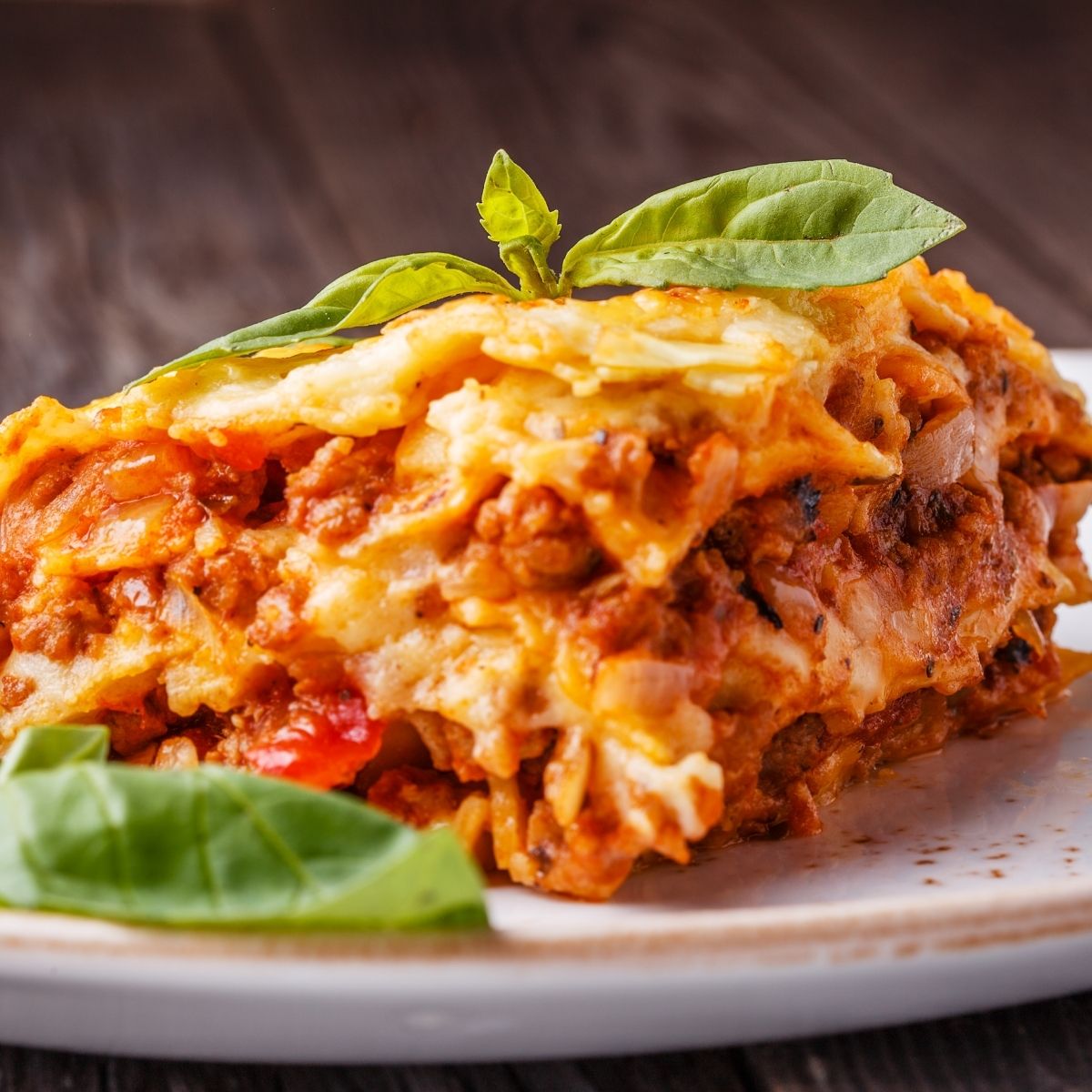 WW slow cooker lasagna on a white plate with fresh basil on top
