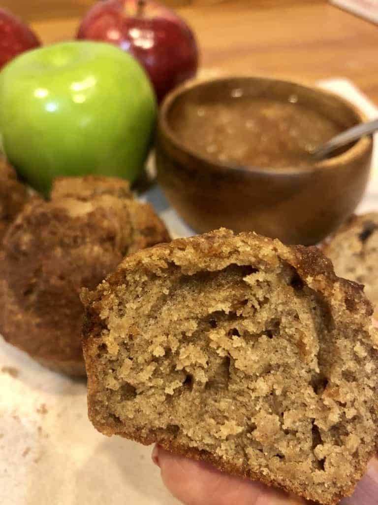 Applesauce infused muffins with a bowl of applesauce and a Granny Smith apple