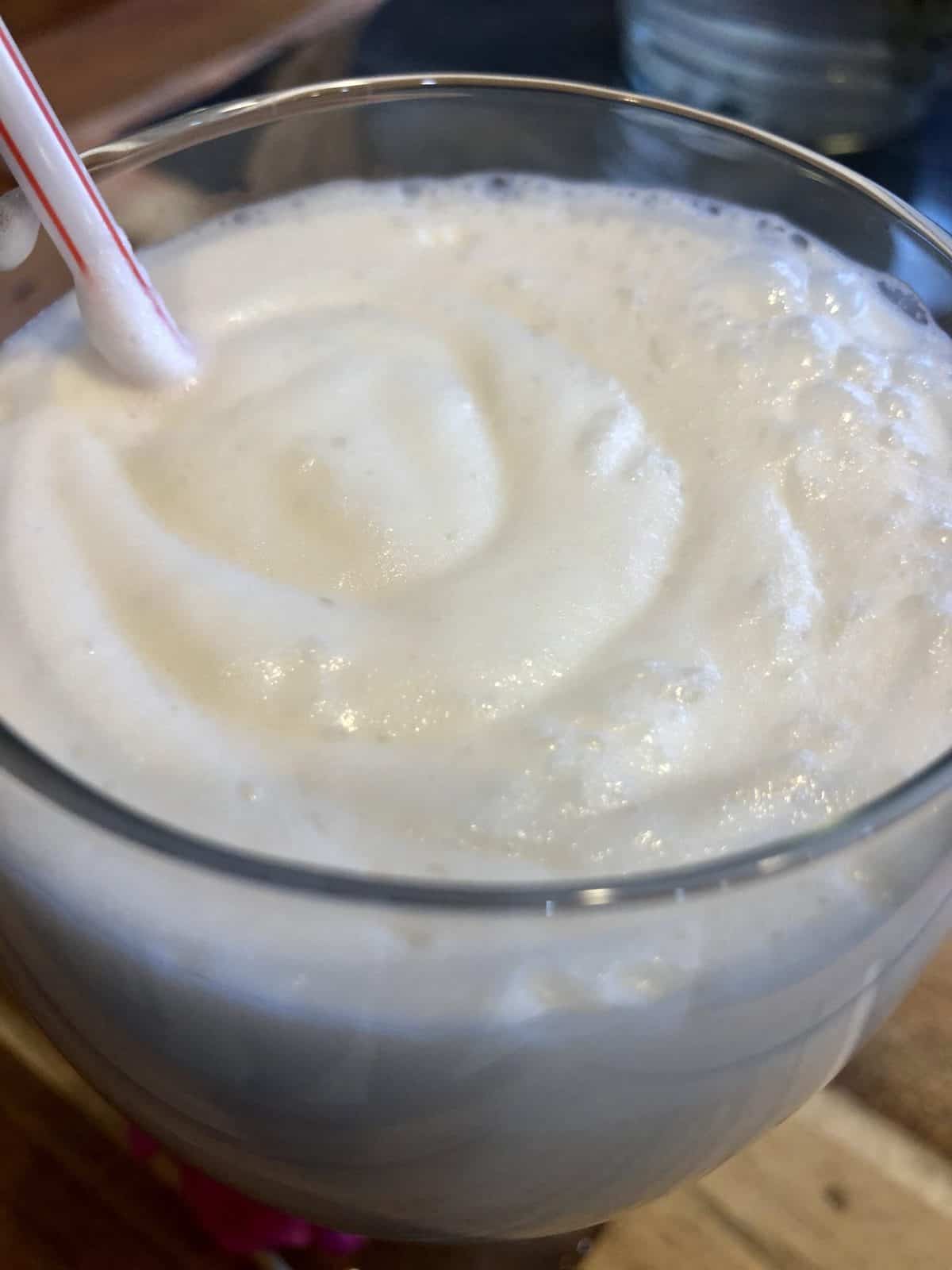 Vanilla Frosty in a clear glass with a straw