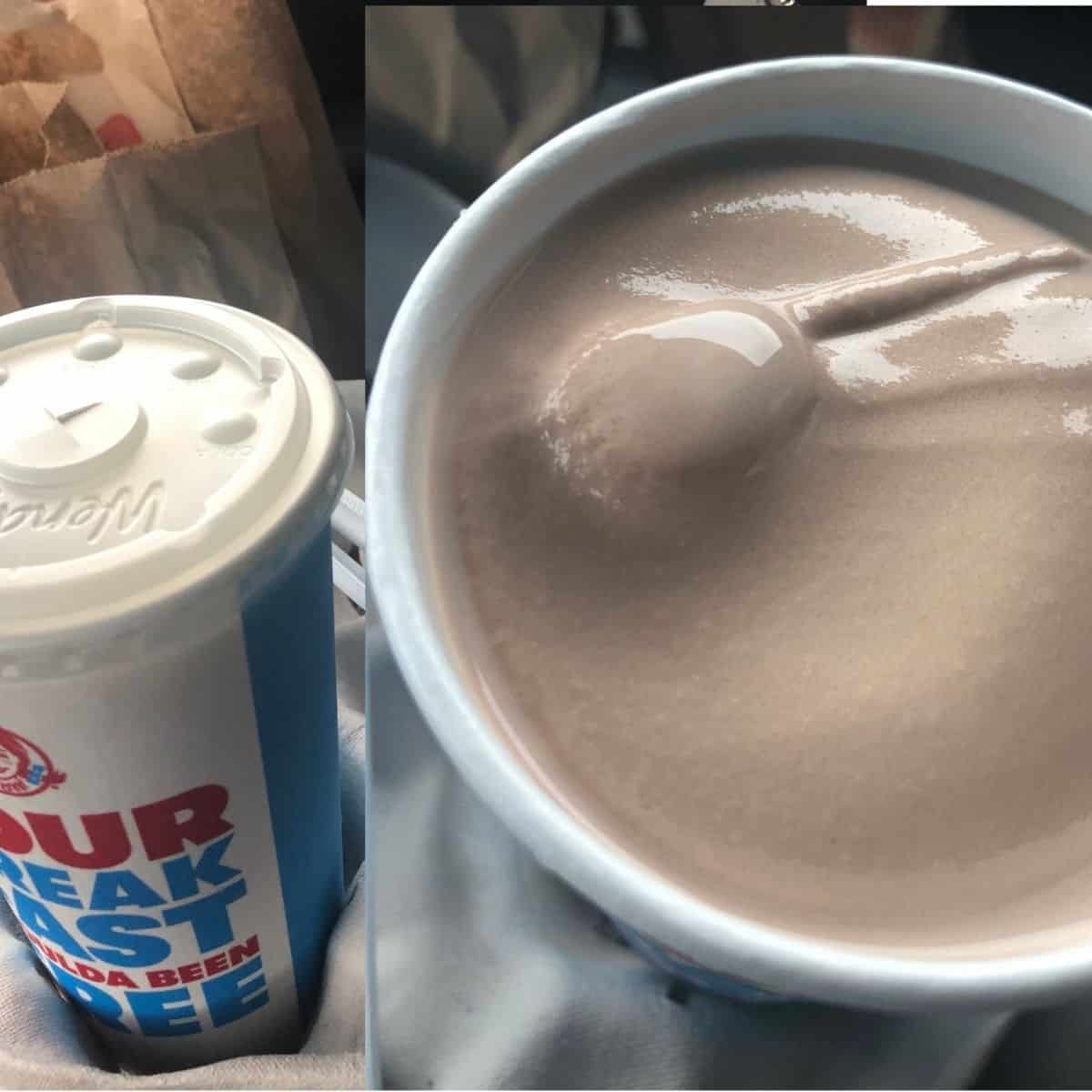 Wendy's Chocolate Frosty and vanilla frosty in a blue and white cup with a lid and a brown paper bag