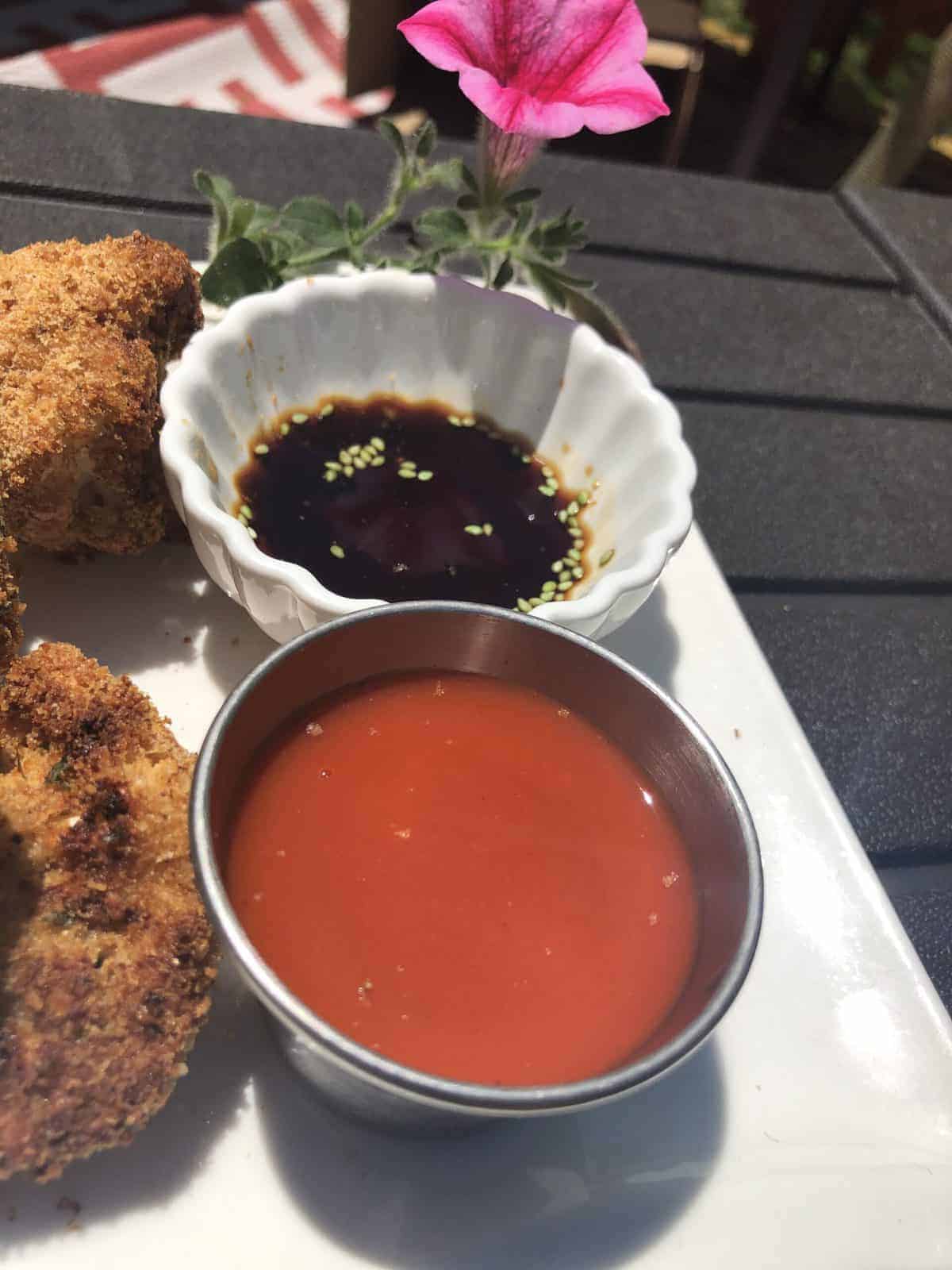  A dipping bowl of Hot Sauce and Soy Sauce on a white plate with baked cauliflower fritters