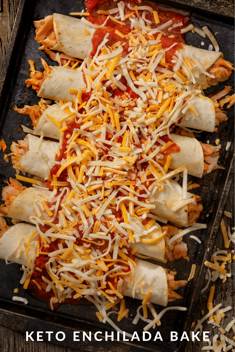  Six Keto Enchiladas in a  Baking dish covered with shredded cheese and salsa