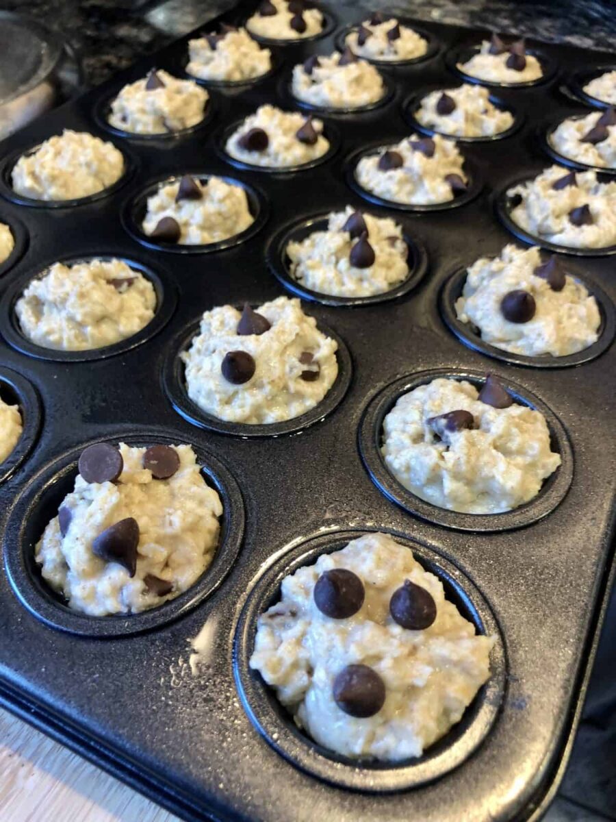 Spooned Muffin Batter with chocolate chips in a baking tin