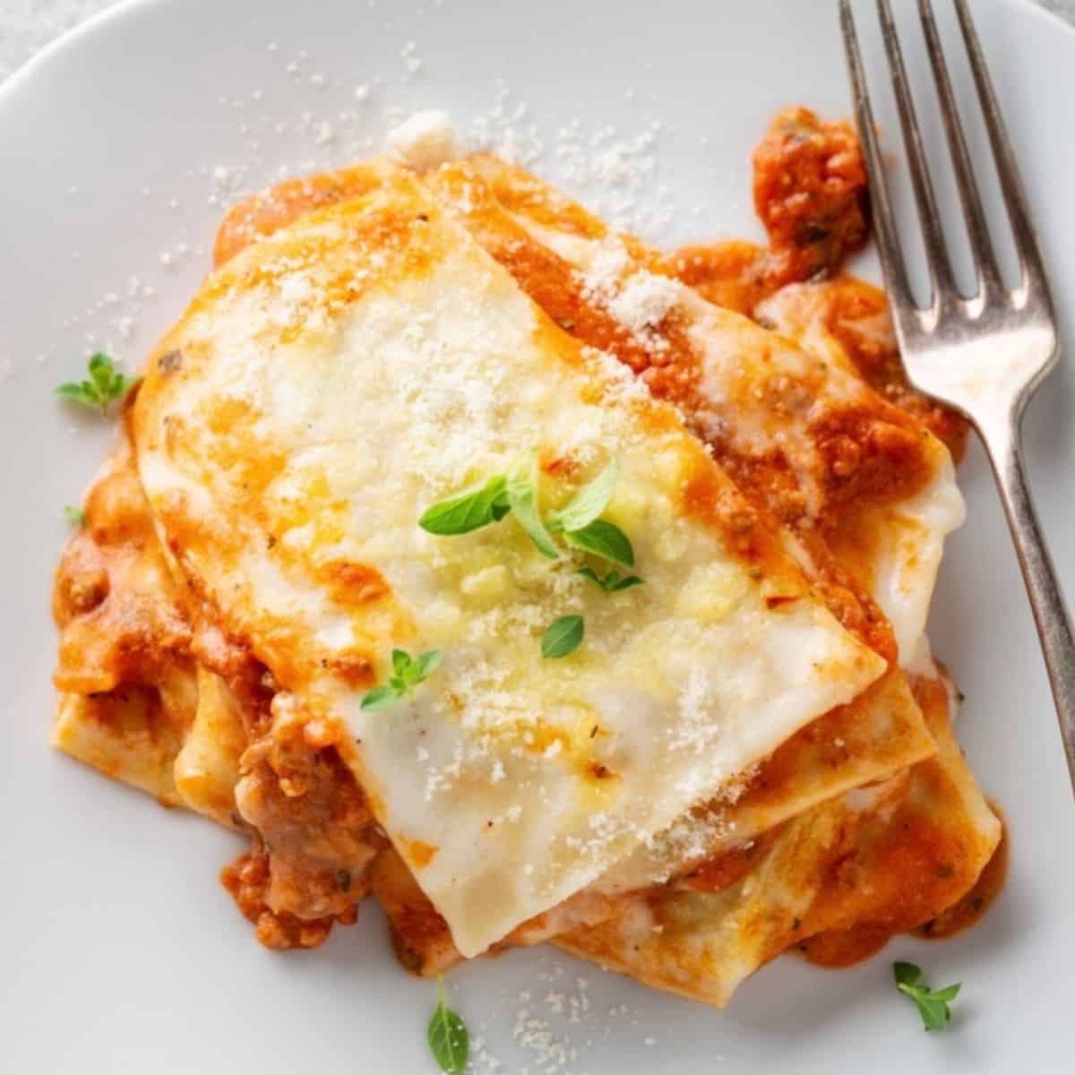 Lasagna on a white plate with a fork