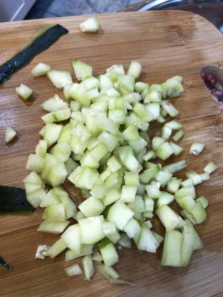 Diced cucumber on a wooden cutting board