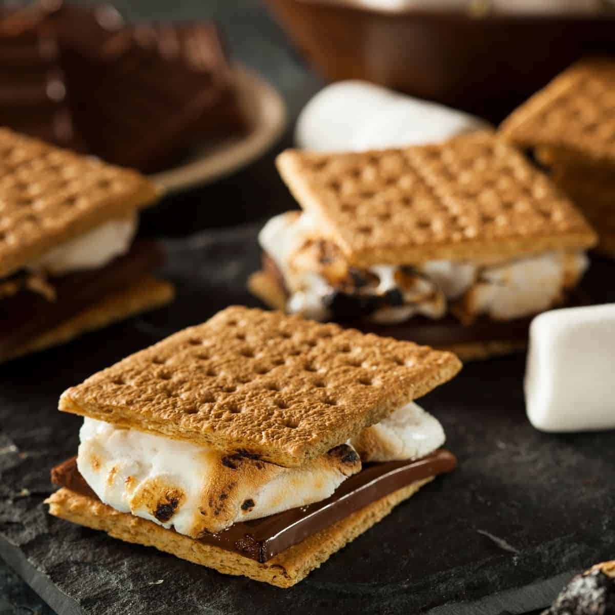 Graham cracker s'mores on a table with marshmallows