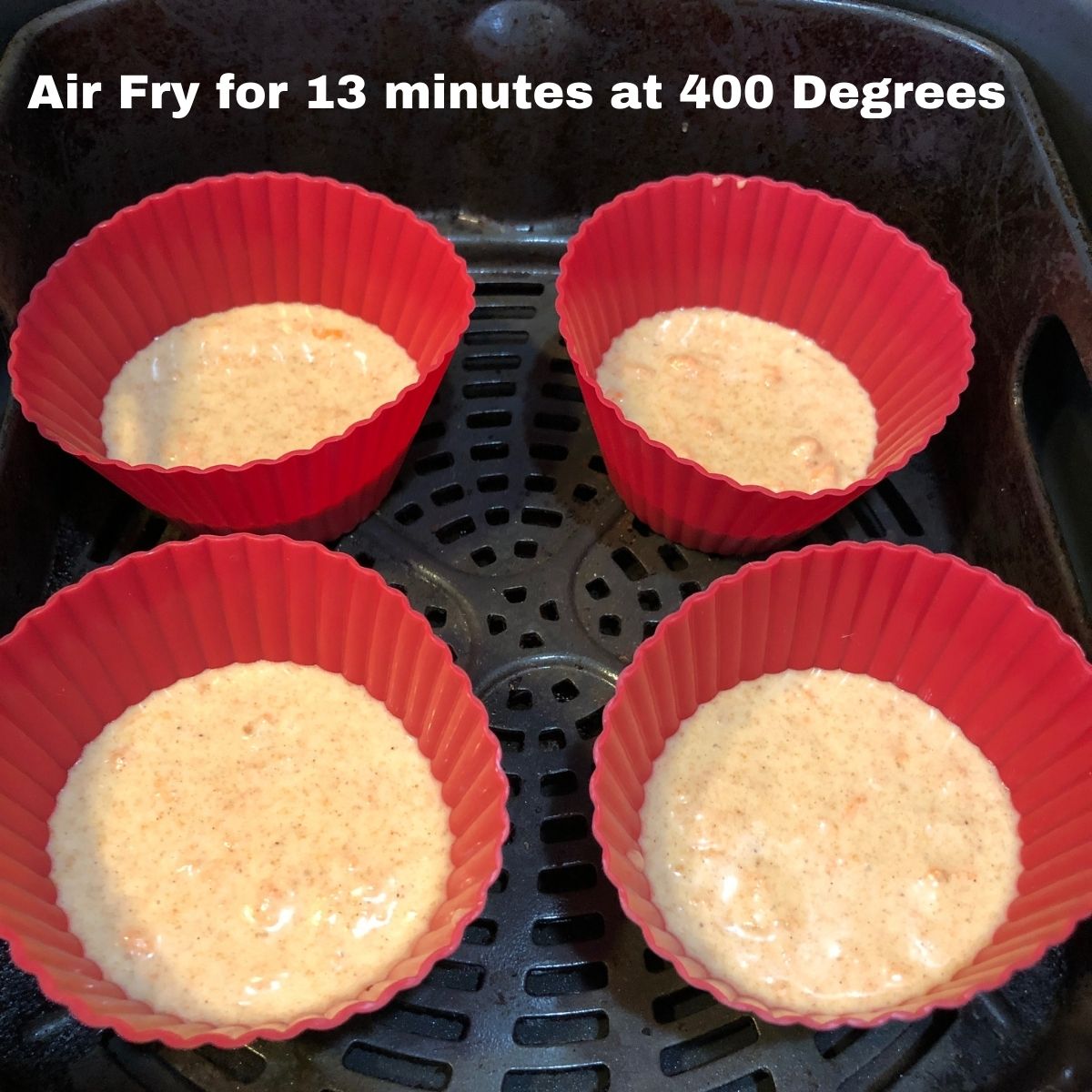 Four silicone muffin cups filled with carrot cake batter in a Ninja Foodi Air Fryer Basket