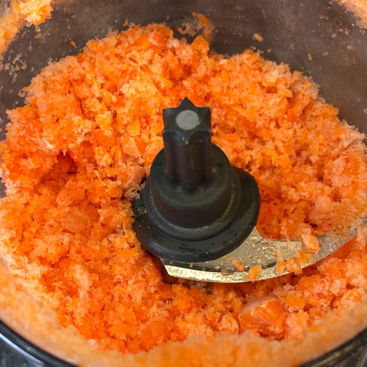 Grated baby carrots in a mini chopper