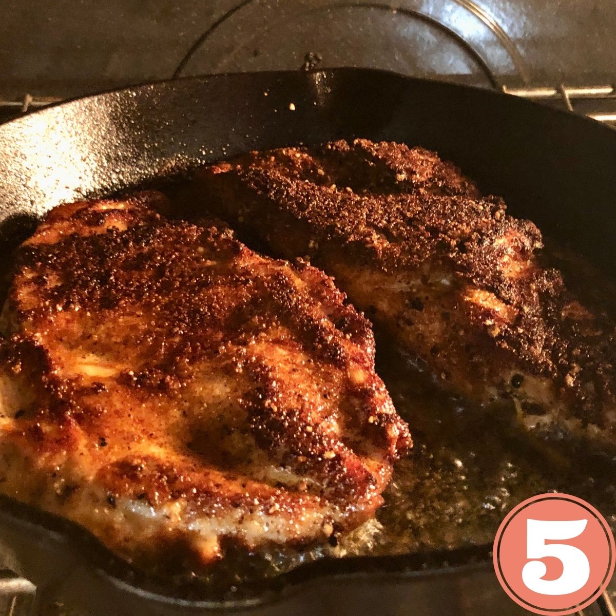 two chicken cutlets in a cast iron skillet on the center rack in the oven