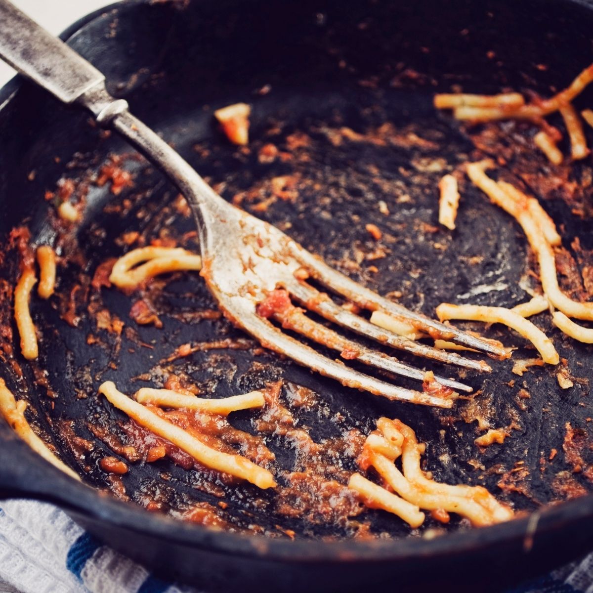 cast iron skillet with a fork and left over spaghetti