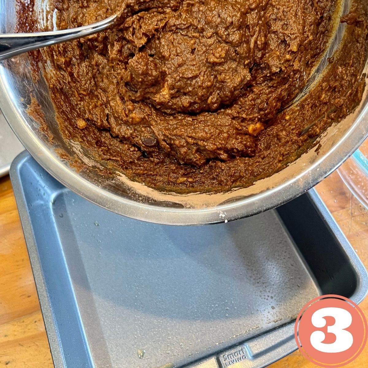 Pouring vegan brownie batter into a baking pan