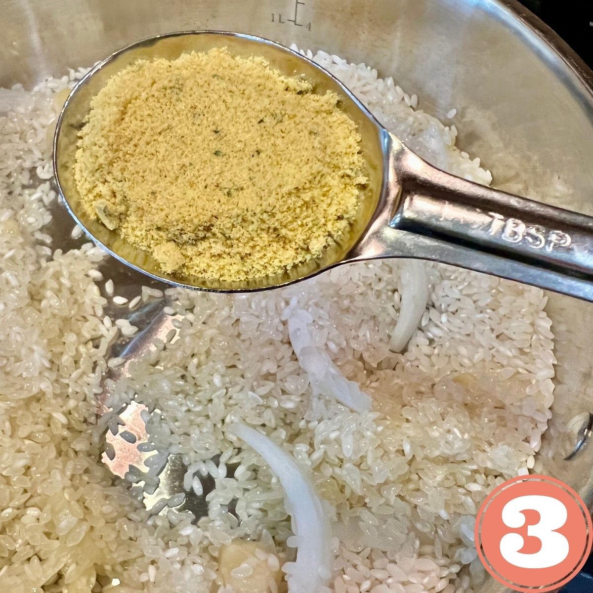Adding one tablespoon of chicken bouillon powder to Mexican Red Rice in a frying pan