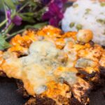 Air fryer Cauliflower Steak with blue cheese crumble and white rice on a black plate
