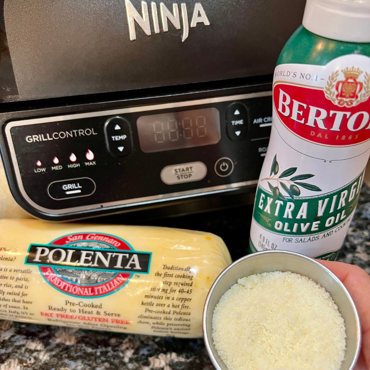 Ninja Foodi Air Fryer with a roll of polenta and Olive Oil Spray and Parmesan Cheese