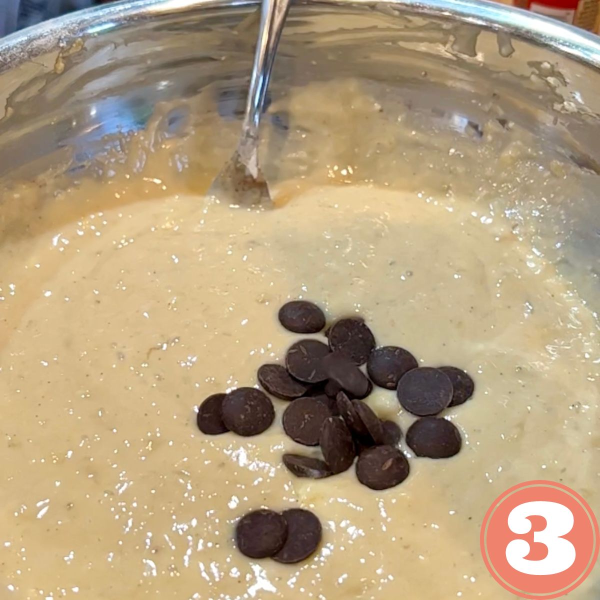 Eggless banana bread batter with chocolate chips in a stainless steel bowl