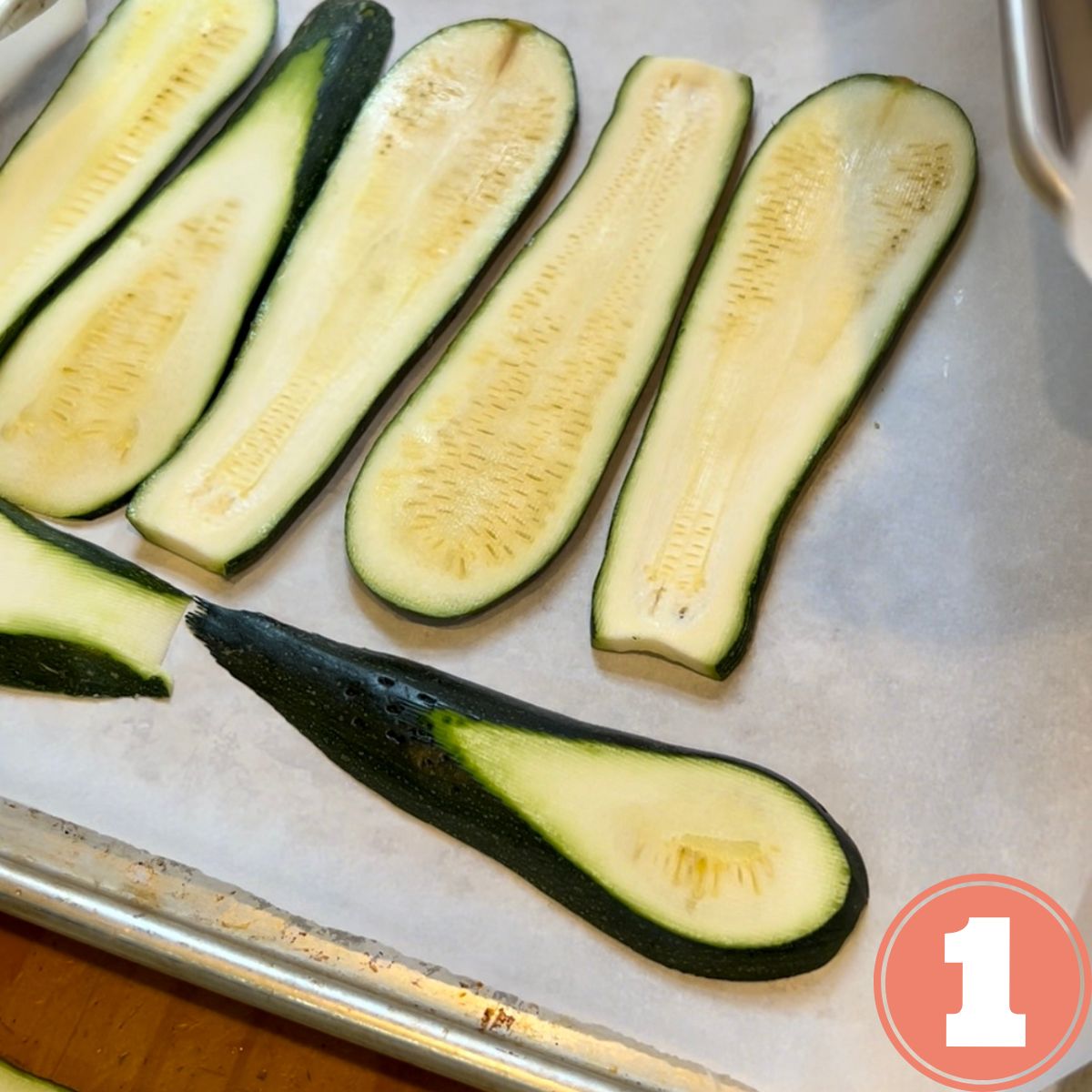 Zucchini slices on a sheet pan lined with white parchment paper
