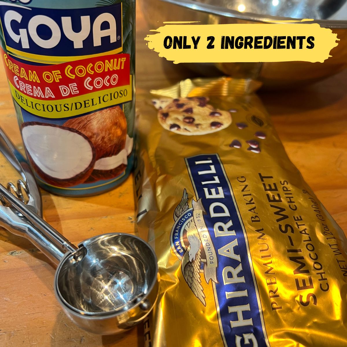 A can of GOYA cream of coconut and a mini stopper and a bag of Ghirardelli chocolate chips and a stainless steel bowl on a wooden table