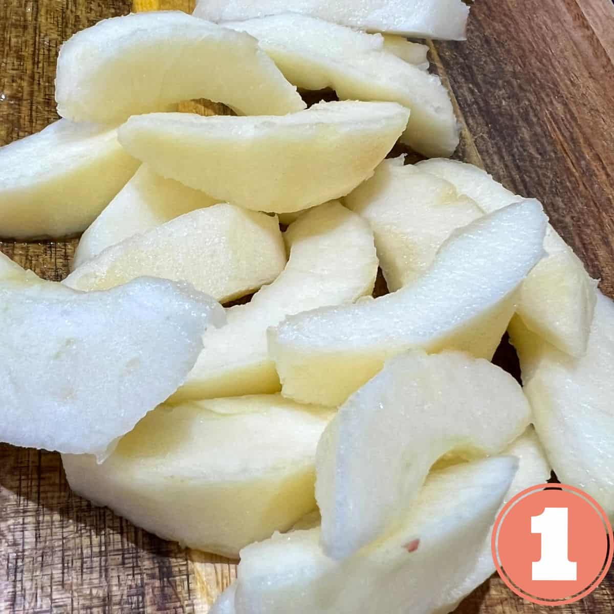 Peeled apple wedges on a cutting board