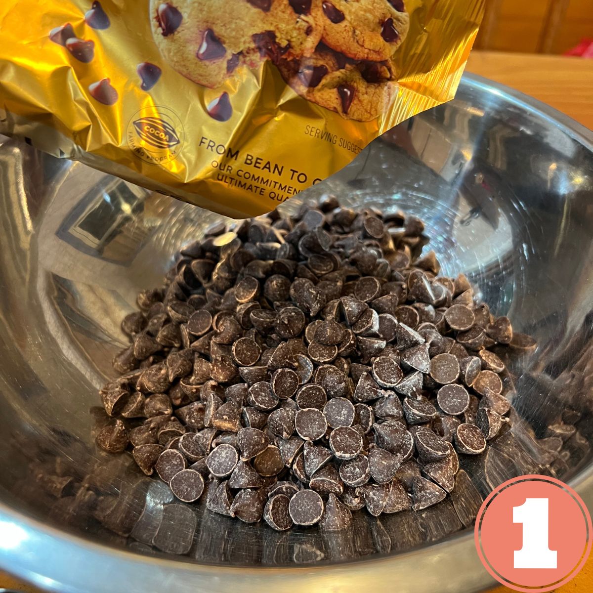 Pouring Ghirardelli chocolate chips into a stainless steel mixing bowl
