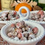Sugar candied cranberries in a white bowl with an orange