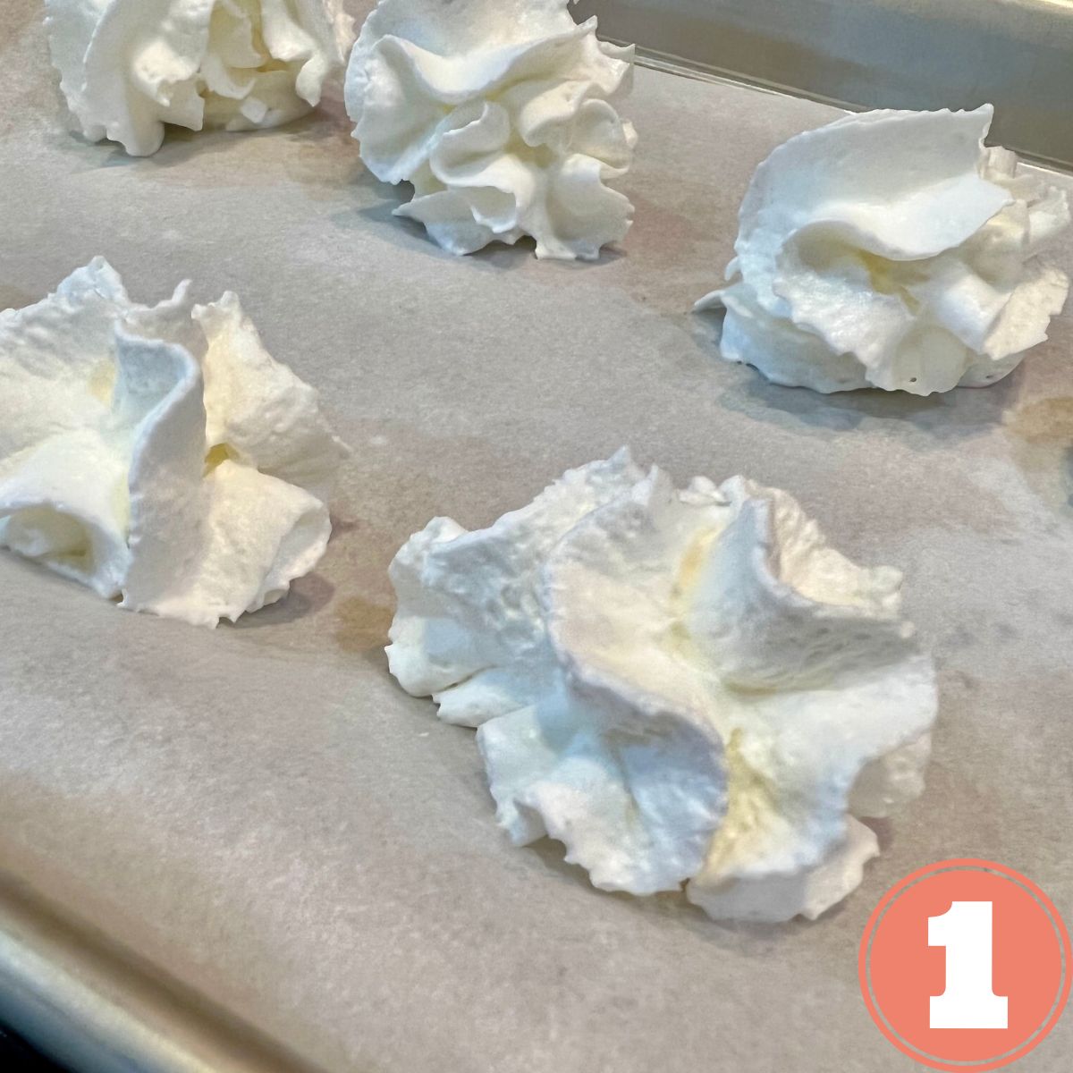 whipped cream dollops on a baking sheet