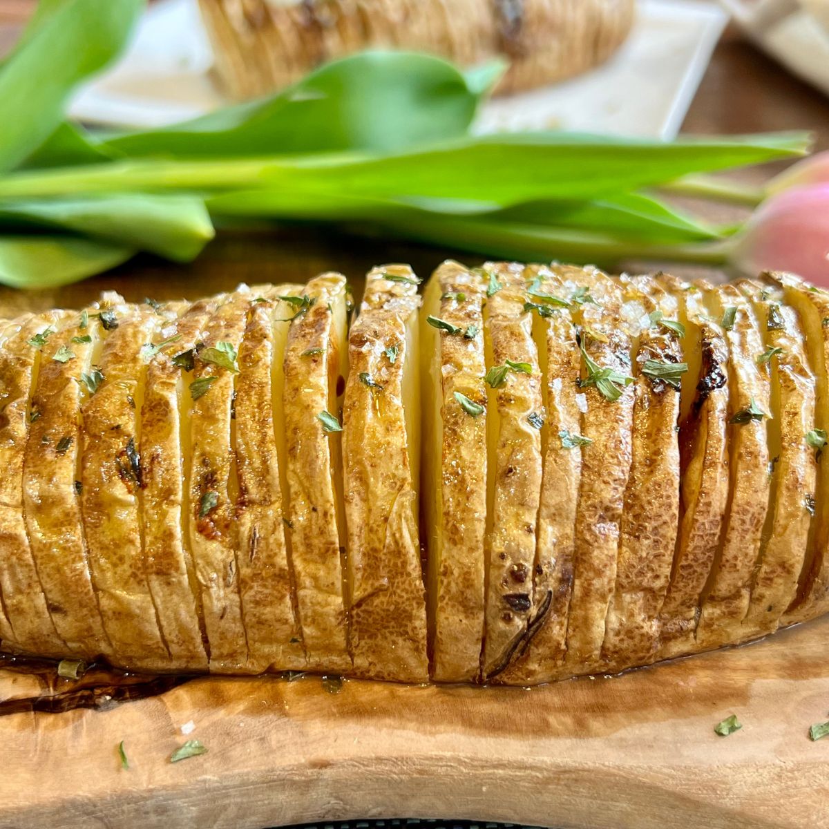 Air fried hasselback potato on a wooden cutting board