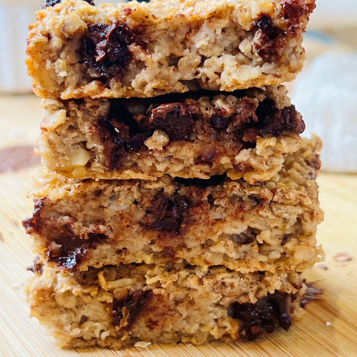 Baked Oatmeal Bars stacked on top of each other on a wooden cutting board