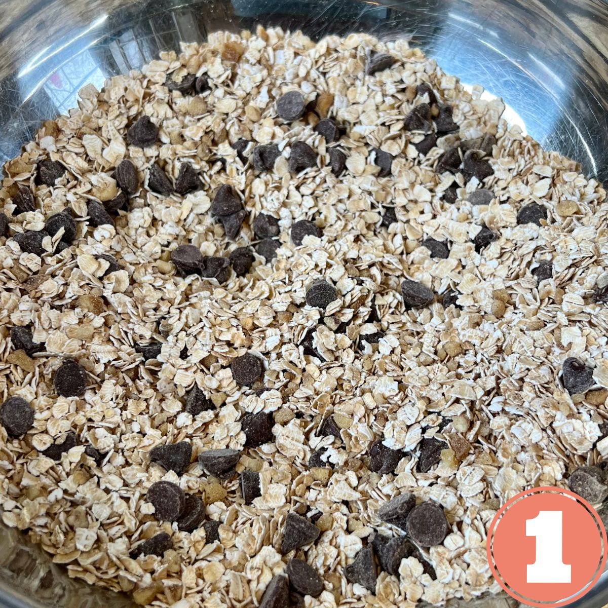 A stainless steel bowl holding baked oatmeal dry ingredients