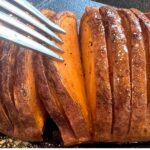 Hasselback air fryer sweet potato with a fork separating a slice