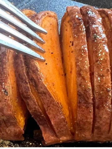 Hasselback air fryer sweet potato with a fork separating a slice