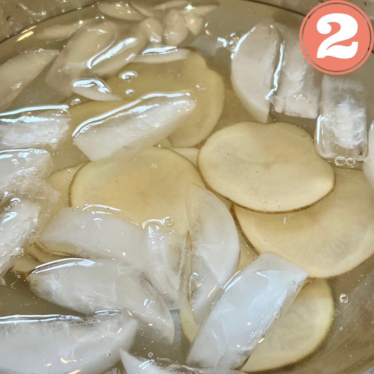 Sliced potatoes in a bowl of ice water