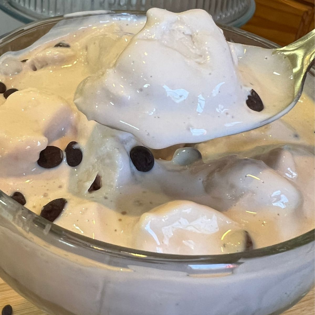 a bowl of high protein rocky road ice cream with a spoon holding a scoop