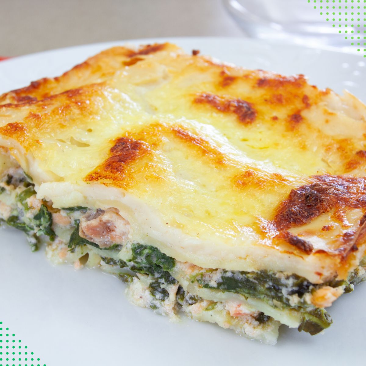 a square of meatless white spinach lasagna on a white plate