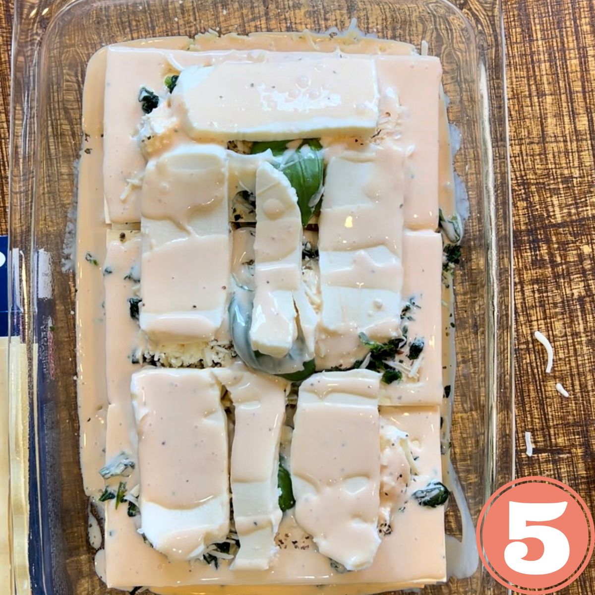 a tray of uncooked white spinach lasagna